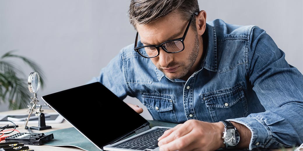 Mann repariert einen kaputten Laptop
